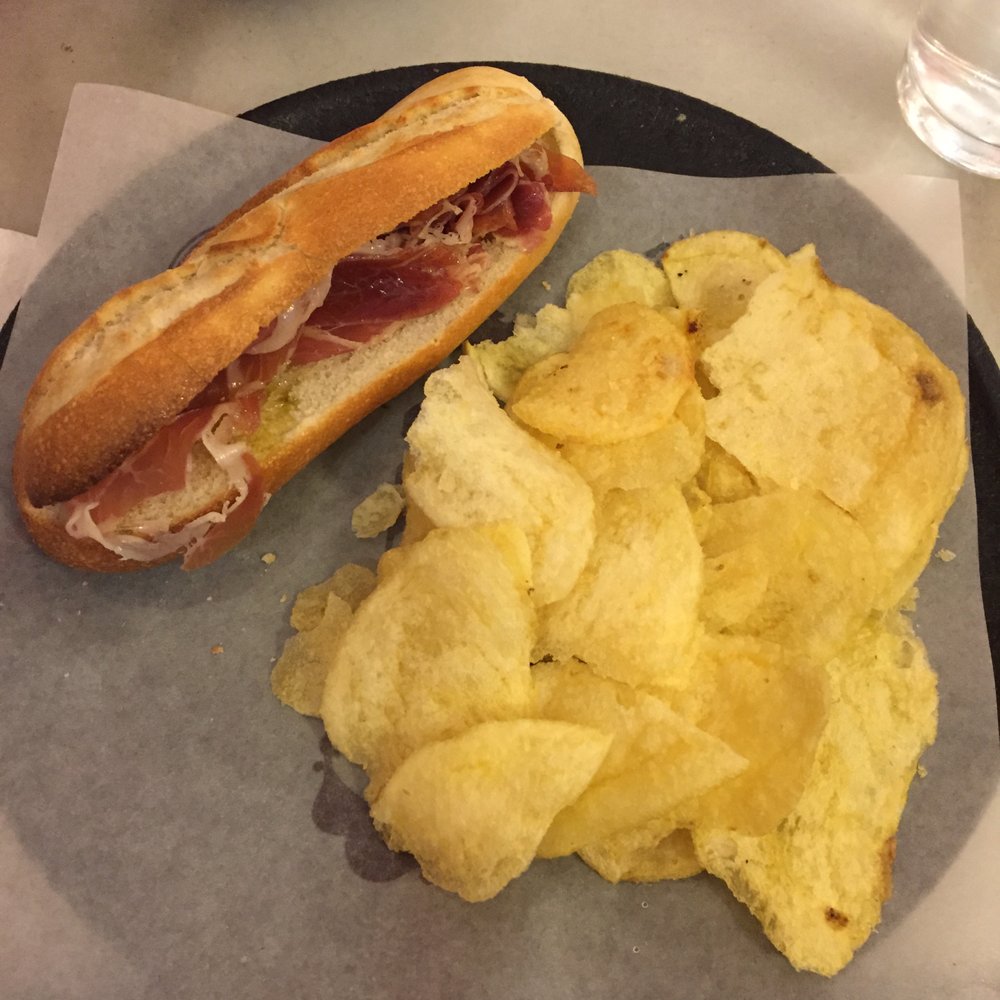 Jamón montadito with a side of chips Jamón montadito with a side of chips