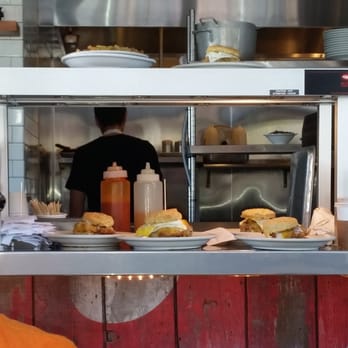 Pine State Biscuits - Food dying in the window will the server is busy in the back chatting away with a coworker. - Breakfast & Brunch Near Me - Portland, Oregon