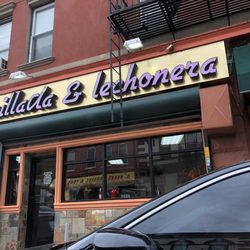 Exterior of the restaurant, also in the door reflection, there's a glimpse of the prevalent issue of double parking. (2/24/2018)