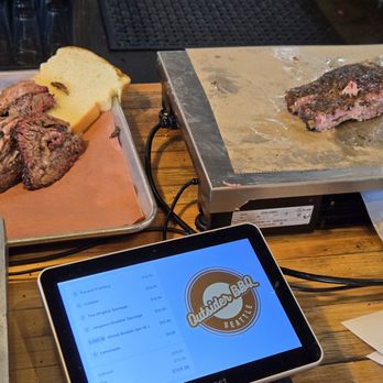 Outsider BBQ & Beer Garden - Brisket on the tray, weighing out the ribs for an exact price (priced per lb) - Barbeque Near Me - Seattle, Washington Outsider BBQ & Beer Garden - Brisket on the tray, weighing out the ribs for an exact price (priced per lb) - Barbeque Near Me - Seattle, Washington