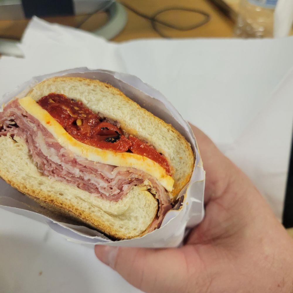 a hand holding a sandwich