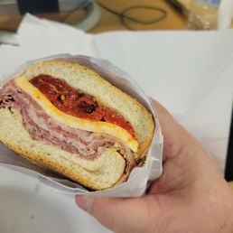 a hand holding a sandwich