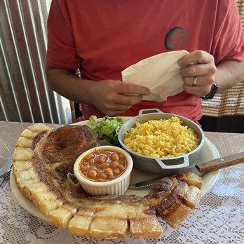 Boriken Restaurant - Chuleta Kan Kan. Included my husband in the photo so you can see how big the dish is! - Puerto Rican Near Me - Beaverton, Oregon