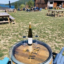 Outdoor seating with lake view and converted barn tasting room Outdoor seating with lake view and converted barn tasting room