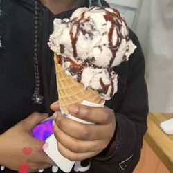Krave Cafe - Double scoop of ultimate Oreo on a waffle cone with chocolate syrup