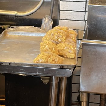 Tulipani - Pre-measured pasta portions - Plastic bags filled with pre-measured pasta are placed on a stainless steel counter in a kitchen setting. - Pasta Shops Near Me - Albuquerque, New Mexico