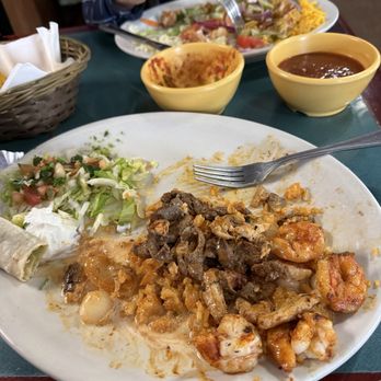 El Tequilla - Beef, chicken, shrimp, onions and peppers on a bed of rice with cheese sauce. - Mexican Near Me - Estherville, Iowa El Tequilla - Beef, chicken, shrimp, onions and peppers on a bed of rice with cheese sauce. - Mexican Near Me - Estherville, Iowa