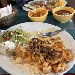 El Tequilla - Beef, chicken, shrimp, onions and peppers on a bed of rice with cheese sauce.