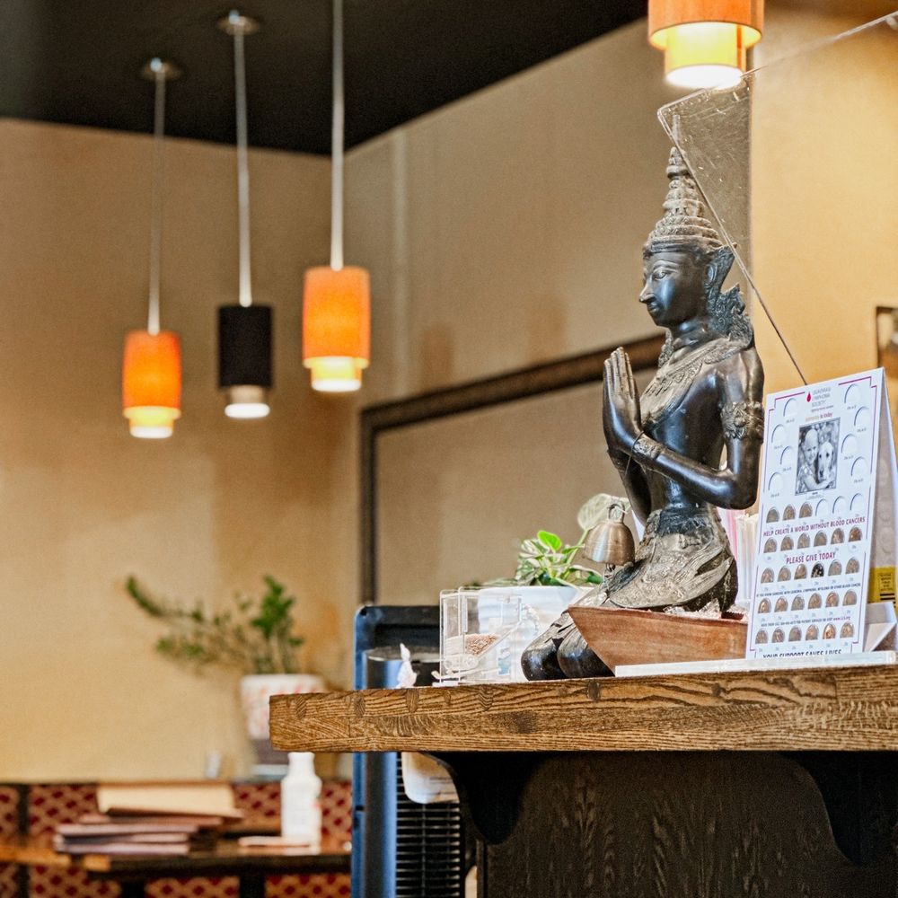 Thawan Thai Cuisine - a buddha statue on a table - Thai Near Me - Norman, Oklahoma Thawan Thai Cuisine - a buddha statue on a table - Thai Near Me - Norman, Oklahoma