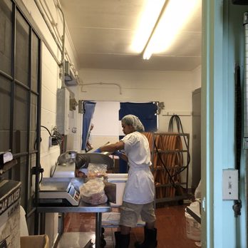 Kukui Sausage Co - Sausage slicing & sausage hanging in the back - Meat Shops Near Me - Honolulu, Hawaii