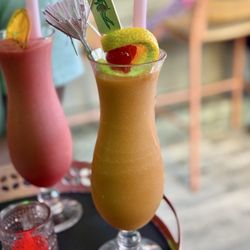 Tiki Chick - Hurricane - a frozen drink with Bacardi Reserva Ocho, Marti Plata Rum, passionfruit, orange, pomegrante, apricot, and lime