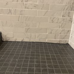 Express Flooring Services - Improperly sloped corner, uneven tiling, horrible caulking