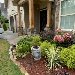 Complete design by Flowerbedcreations's added roof over door and columns. Planted all shrubs and red mulch with rock boarder in flowerbeds