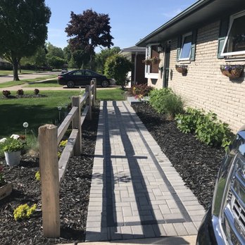 Eager Beaver Lawn & Snow - a driveway with a fenced in area - Landscaping Near Me