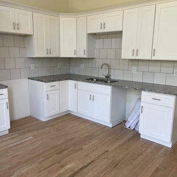 Camcon - a kitchen with white cabinets and wood floors - General Contractors Near Me Camcon - a kitchen with white cabinets and wood floors - General Contractors Near Me