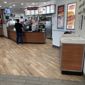 Wendy's - the inside of a fast food restaurant - A Wendy's restaurant interior showing a counter with a customer ordering, digital menu boards, and a white tiled wall with promotional posters. - Fast Food Near Me - Patterson, California