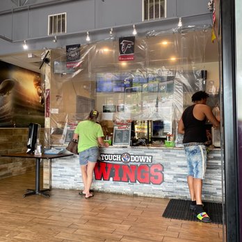 Touchdown Wings - two people standing in front of a counter - Chicken Wings Near Me - Austell, Georgia