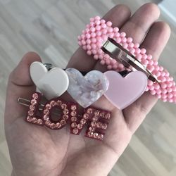 Sui Ava Store - Fine hårspænder fra Suiava. Det øverste lyserøde kostede 90 kroner, Love-hårspændet 75 kroner og de lyserøde med hjerter 80 kroner.