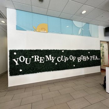 Feng Cha Coppell - Inside - A wall features a green hedge with white letters spelling 'YOU'RE MY CUP OF BOBA TEA' in a tea shop interior. - Bubble Tea Near Me - Coppell, Texas