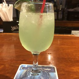 a drink in a glass with a straw and a lime slice a drink in a glass with a straw and a lime slice