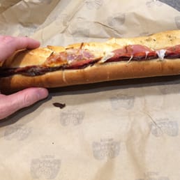 a hand holding a sub sandwich