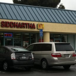 two cars parked in front of a store two cars parked in front of a store