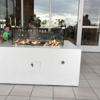 Myth - a man and a child sitting in front of a fire pit - Cocktail Bars Near Me - Orlando, Florida