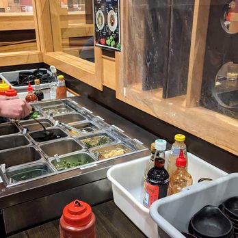 Ibasaw - a man preparing food in a kitchen - Sushi Bars Near Me - Malden, Massachusetts