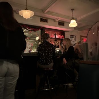 Midnights - a group of people sitting at a bar - Cocktail Bars Near Me - Brooklyn, New York