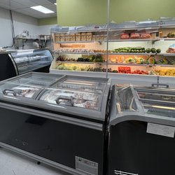 BD International Market - Frozen prepackaged meat section and fresh vegetables behind