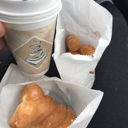 a person holding a cup of coffee and croissants a person holding a cup of coffee and croissants