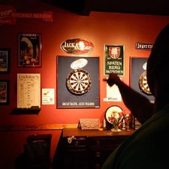 R Bar - a man pointing at a dart on a wall - Sports Bars Near Me - Houston, Texas R Bar - a man pointing at a dart on a wall - Sports Bars Near Me - Houston, Texas