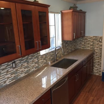 Unicorn Group USA - a kitchen with wood cabinets and granite countertops - General Contractors Near Me Unicorn Group USA - a kitchen with wood cabinets and granite countertops - General Contractors Near Me
