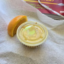 Juice Max - "Coldshot" (turmeric, garlic, ginger, lemon, lime, & an orange slice on the side) ‍