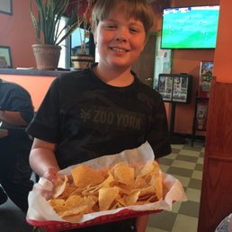 a boy holding a basket of chips a boy holding a basket of chips