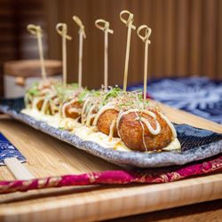 Zuru Ramen Bar - Crispy octopus-filled balls on egg salad, topped with Japanese mayo, eel sauce, bonito flakes, seaweed, and chili threads