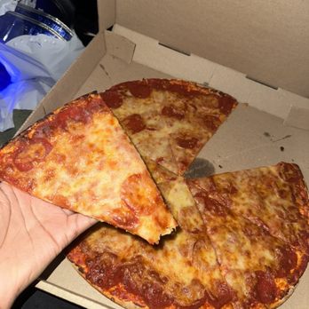 Upper Crust Pizza - a hand holding a slice of pizza - Pizza Near Me - Milwaukee, Wisconsin