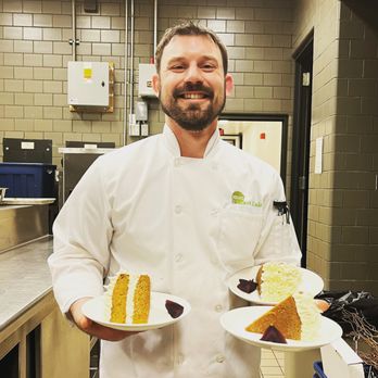 The Full Nelson - a chef holding two plates of food - Caterers Near Me The Full Nelson - a chef holding two plates of food - Caterers Near Me