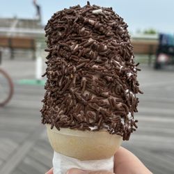 Vanilla/chocolate twist soft serve with chocolate sprinkles on a cone