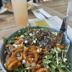 Fairhope Social Club - Curly fry salad with smash burger on top