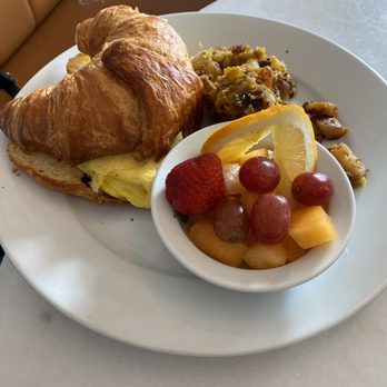 Immigrant Son Caffe - And omelette sandwich on croissant with fruit salad and potatoes - New American Near Me - Ventura, California