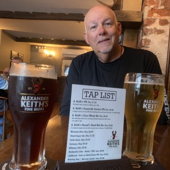 The Brown Hound Public House - a man sitting at a table with two glasses of beer - Pubs Near Me - Halifax, Nova Scotia