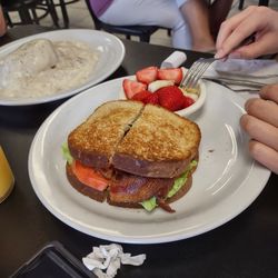 Royal Biscuit - Avocado sandwich with fruit as a side.