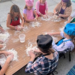 Kids having fun making fresh pizza dough for a birthday party.