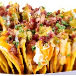TraePay's Loaded Nachos (Cheese & Chili sauce, topped w/ shredded cheese, jalapenos, bacon bits, drizzled w/ ranch, buffalo sauce, &chipotle