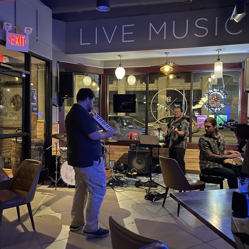 The Brick Bar - a man playing a musical instrument - Cocktail Bars Near Me - Toledo, Ohio