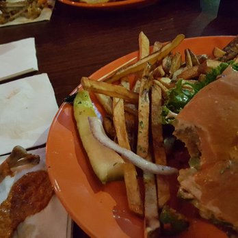 The Local 907 - Chicken burger all bitten up, with fries and pickle - Pubs Near Me - Renton, Washington