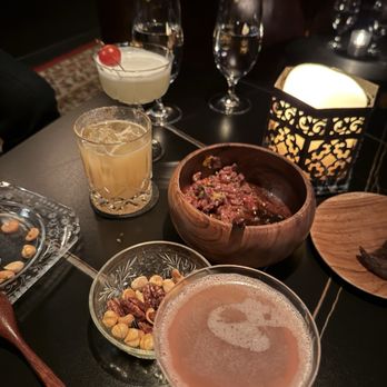 The Aviary - From left to right, caprise drink, tonksolu, blood orange vodka , nuts and beef tartare with pumkinnickle chips. - Cocktail Bars Near Me - Chicago, Illinois