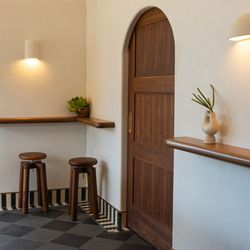 Reunion & Company - Front bar nook with stools and pocket door to lounge