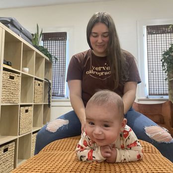 Verve Chiropractic - Baby getting a chiropractic adjustment to support with breastfeeding/tongue tie issues, while smiling and enjoying every moment! - Chiropractors Near Me - Orange, California Verve Chiropractic - Baby getting a chiropractic adjustment to support with breastfeeding/tongue tie issues, while smiling and enjoying every moment! - Chiropractors Near Me - Orange, California
